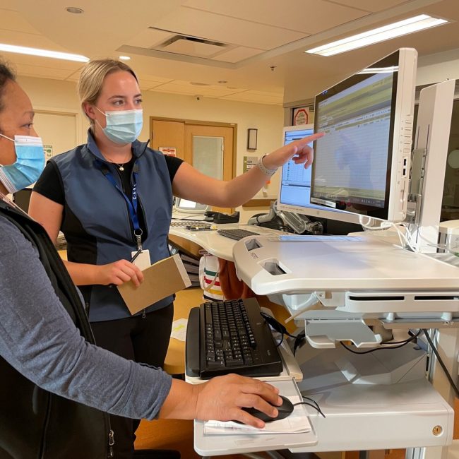 IHealth支持工作人员Johanna Haley（R）在RJH的6楼帮助Eloisa。